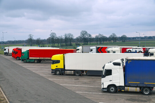 Various types and colors of cabins. Trucks parked in a row. Truck stop. Break in a trip.