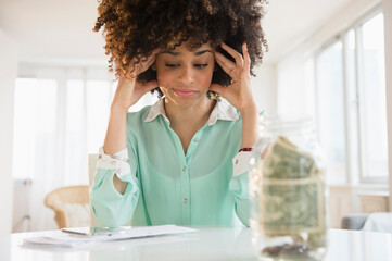 Stressed mixed race woman paying bills