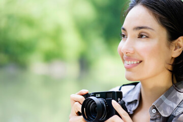 Hispanic woman photographing outdoors