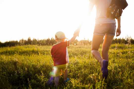 Mother and son walking in rural field
