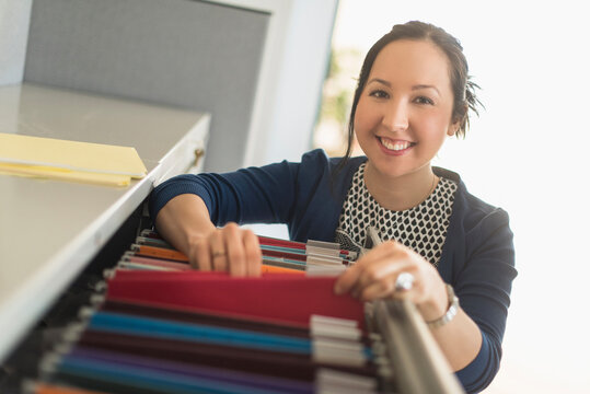 Mixed race businesswoman choosing files in office