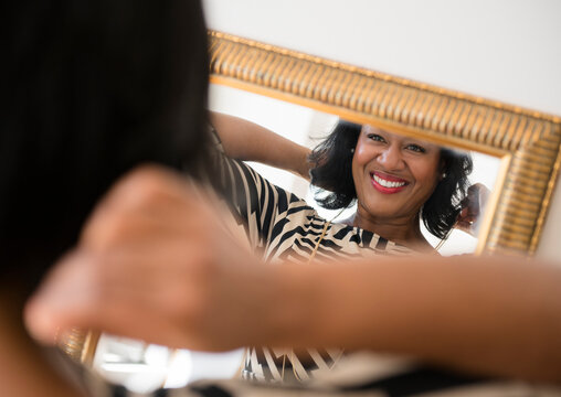 Black woman admiring herself in mirror