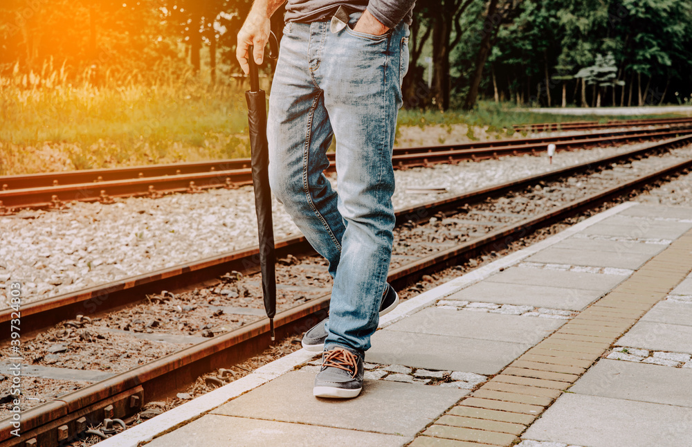 Poster The man is walking on the platform, at the train station.