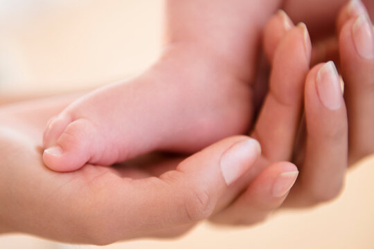 Close up of mother holding bare foot of baby