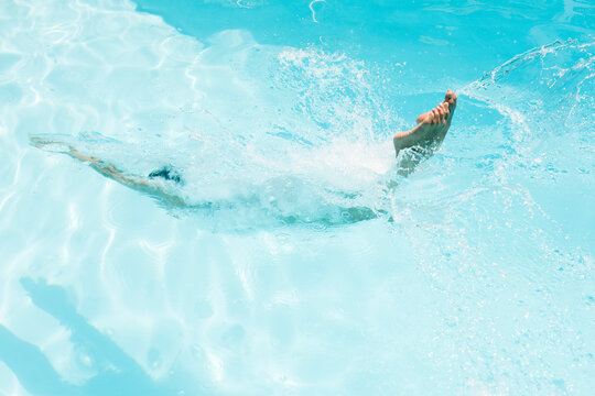 Caucasian woman diving in swimming pool