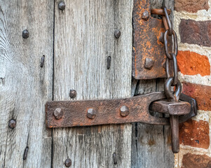 Historic Ancient rusty lock on gate with bricks