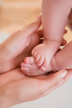 Close up of mother holding bare feet of baby