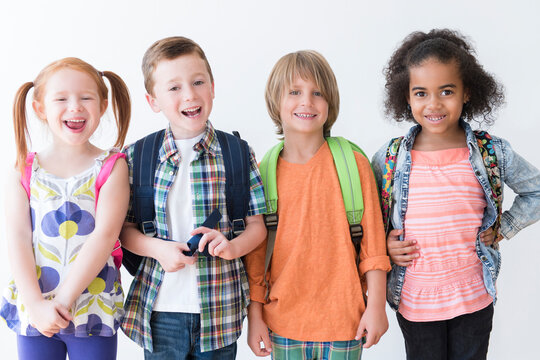 Smiling children wearing backpacks