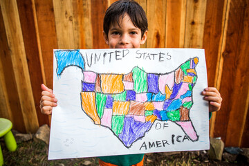 Mixed race boy holding United States map
