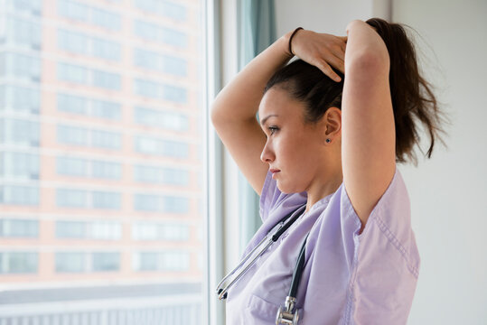 Nurse tying her hair up in hospital