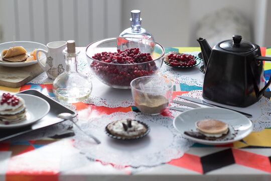 Breakfast table with tea, pastries and fruit on lace doilies