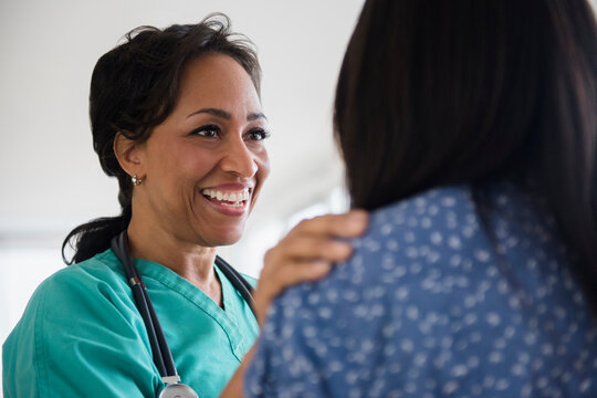 Smiling nurse comforting patient