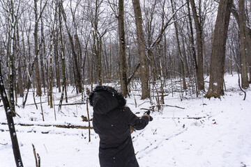 Fototapeta na wymiar Woman catches falling snow in forest