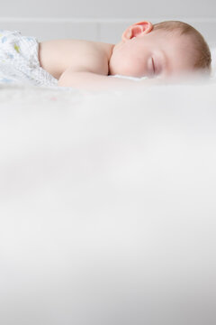 Caucasian baby boy sleeping on bed