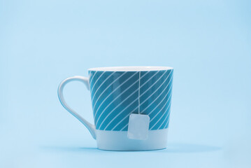 Blue cup of tea on a blue background with a copy space, cheerful and positive office concept
