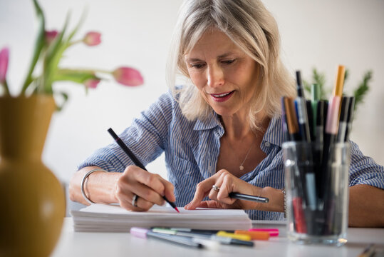 Caucasian woman sketching on pile of paper