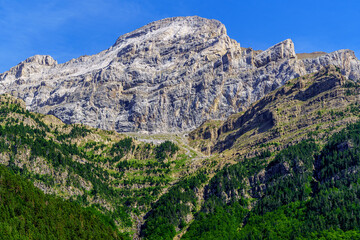 Fototapeta na wymiar High mountain summit, vertical rock wall in Pyrenees Ordesa. Challenge overcoming achieve the impossible. 
