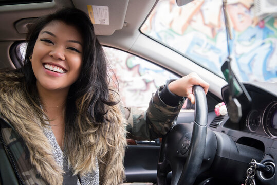 Portrait of smiling Mixed Race woman driving car