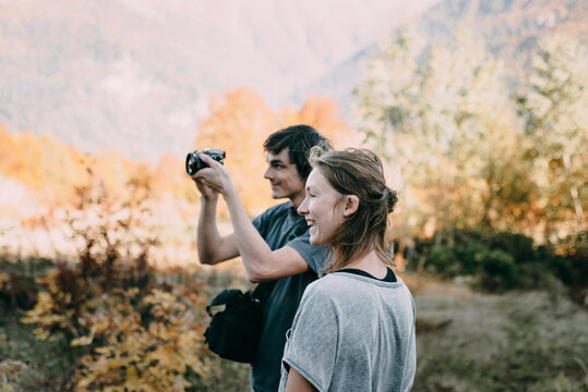 Caucasian couple photographing with camera in autumn