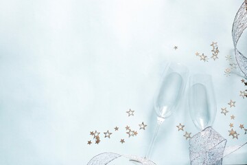 two champagne glasses and silver stars on light blue background. Valentine'd day, wedding, christmas greeting card concept