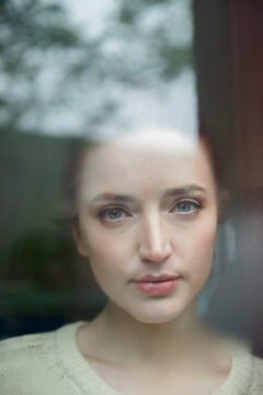 Serious Caucasian woman behind foggy window