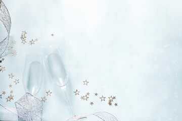 two champagne glasses and silver stars on light blue background. Valentine'd day, wedding, christmas greeting card concept © Eugenia