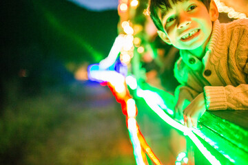 Neon lights glowing on face of Mixed Race boy