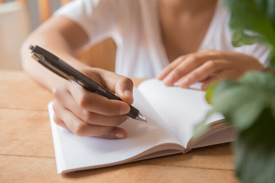 Hands of African American woman writing in journal