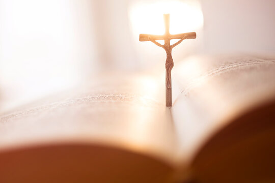 Backlit cross in open Bible