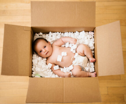 Baby girl (2-5 months) in cardboard box