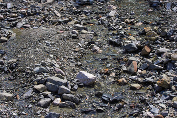 Close-up gray stones and small stream.