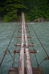 Scene with mountain river and suspension bridge