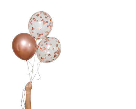 bright  balloons isolated on white background.  stylish party with balloons. round bronze and transparent balloon. Hand hold three balloon. children's holiday. image for birthday greeting card 