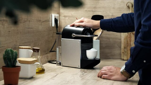 Authentic shot of young man making bio coffee at home - Espresso machine relax concept