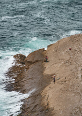 two fishermen fishing on the shore wall