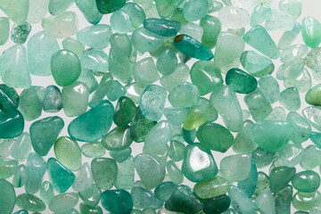 Macrophotography of natural aventurine. Ornamental stones close-up. The texture of green pebbles with flecks and scuffs.