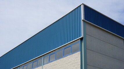 Fototapeta na wymiar industrial warehouse building roof against sky background
