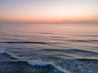 Soft haze and pastel coloured sunrise seascape