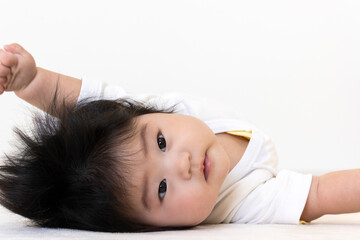Obraz premium 仰向けでカメラ目線の赤ちゃん(0歳、生後5か月、女の子)