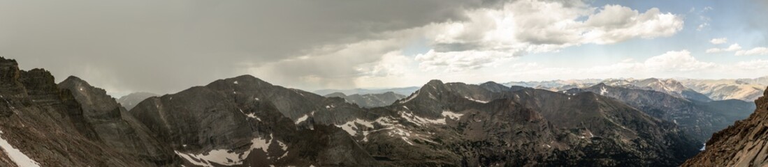 Fototapeta premium Panorama shot of rocky hills and storm clouds around Longs peak in rocky mountains national park in america