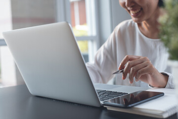 Casual business woman or freelancer working on laptop computer at home office