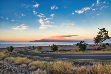 Obraz premium Curve in an asphalt road seemingly leading to paradise.