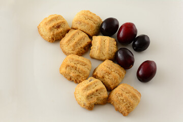 Crunchy cranberries cookies with fresh raw cranberries on white plate background
