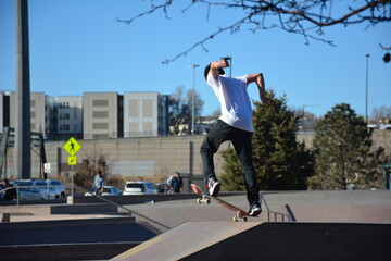 Skaterboarder in the air doing tricks in a skatepark.
