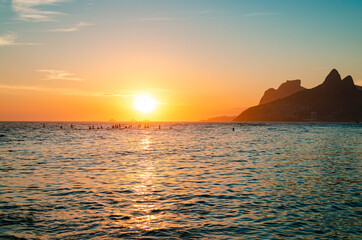 Sunset in rio de janeiro with gavea stone and the two brothers' hill in the background.