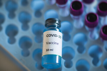 Concept of Covid 19 vaccine vaccinating, development and creation, doctor or scientist in laboratory holding a single dose of  2019-ncov vaccine, a syringe and ampule with SARS-CoV-2 vaccination