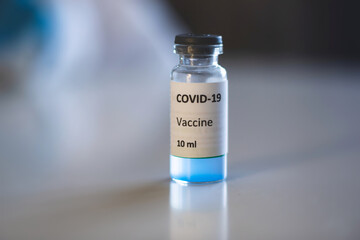 Concept of Covid 19 vaccine vaccinating, development and creation, doctor or scientist in laboratory holding a single dose of  2019-ncov vaccine, a syringe and ampule with SARS-CoV-2 vaccination