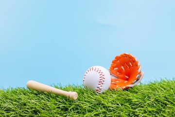 Baseball is on green grass blue sky background