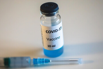 Concept of Covid 19 vaccine vaccinating, development and creation, doctor or scientist in laboratory holding a single dose of  2019-ncov vaccine, a syringe and ampule with SARS-CoV-2 vaccination