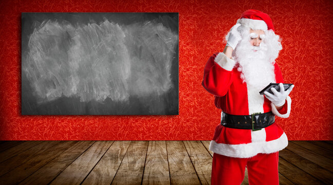 confused santa claus in front of a blackboard on red background